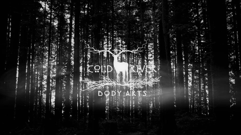 Cold River Body Arts Logo against a foggy forest background.
